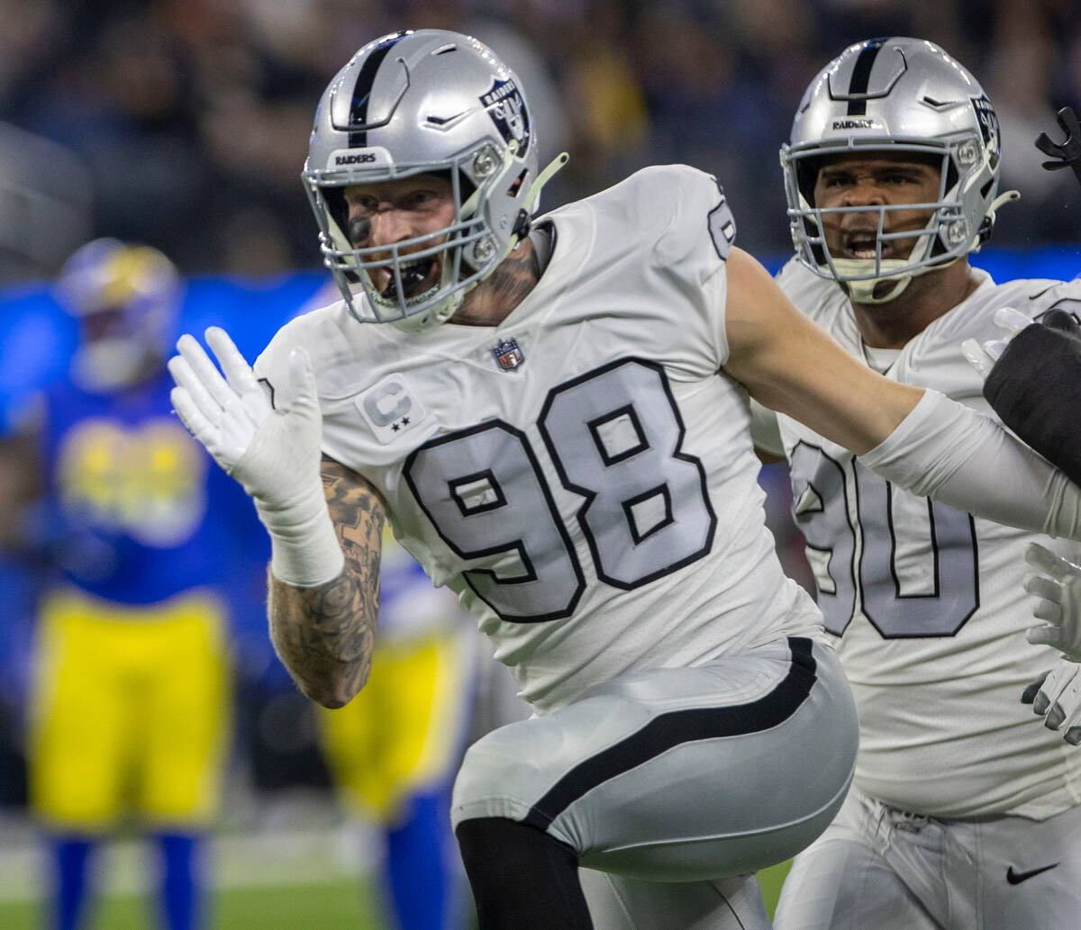 Raiders defensive end Maxx Crosby (98) celebrates his tackle for loss with defensive tackle Jer ...