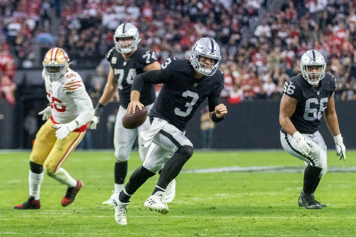 Raiders quarterback Jarrett Stidham (3) rushes with the football as offensive linemen Kolton Mi ...