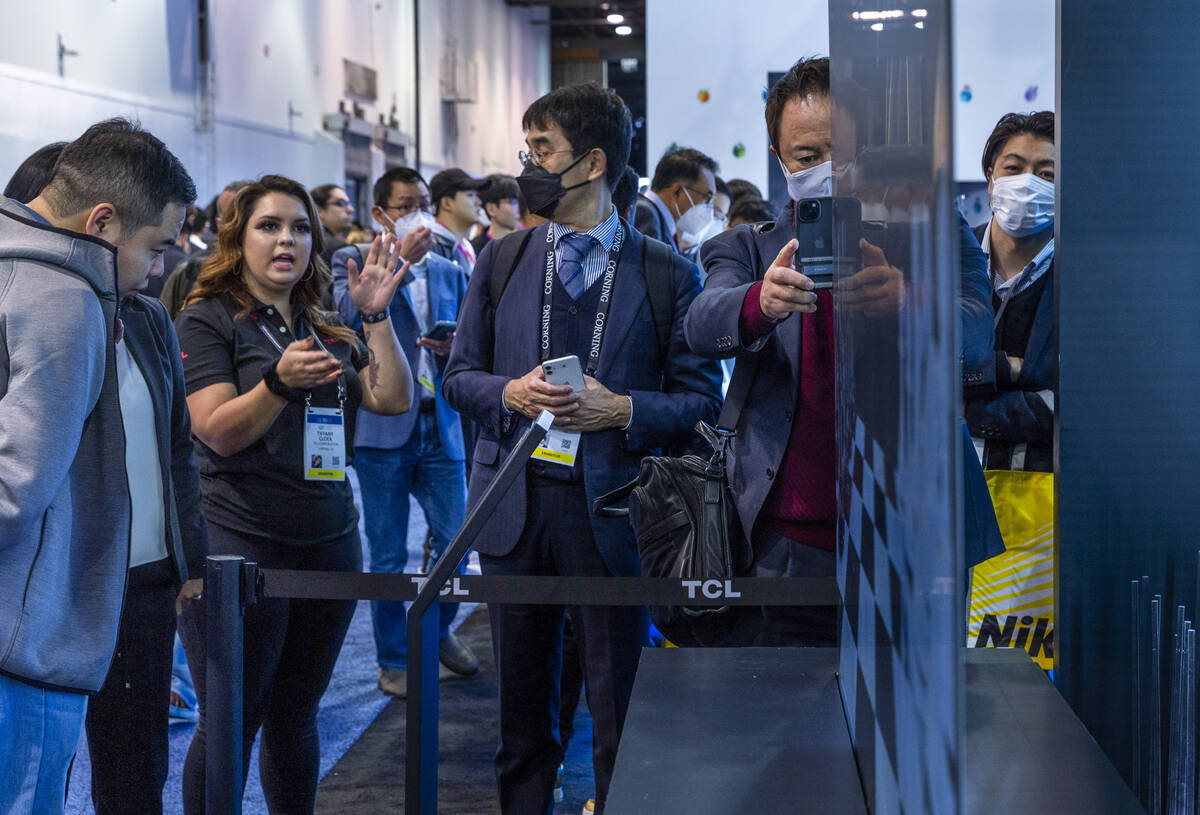 Attendees check out an Ultra Slim 8K Mini LED television during the opening day of CES 2023 at ...