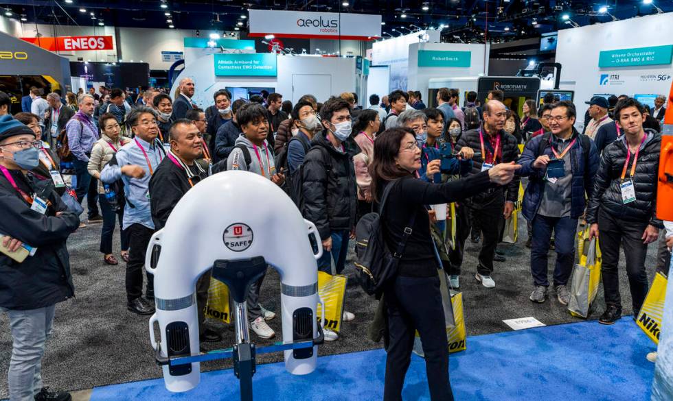 Attendees learn about a U SAFE remote controlled lifesaving buoy during the opening day of CES ...