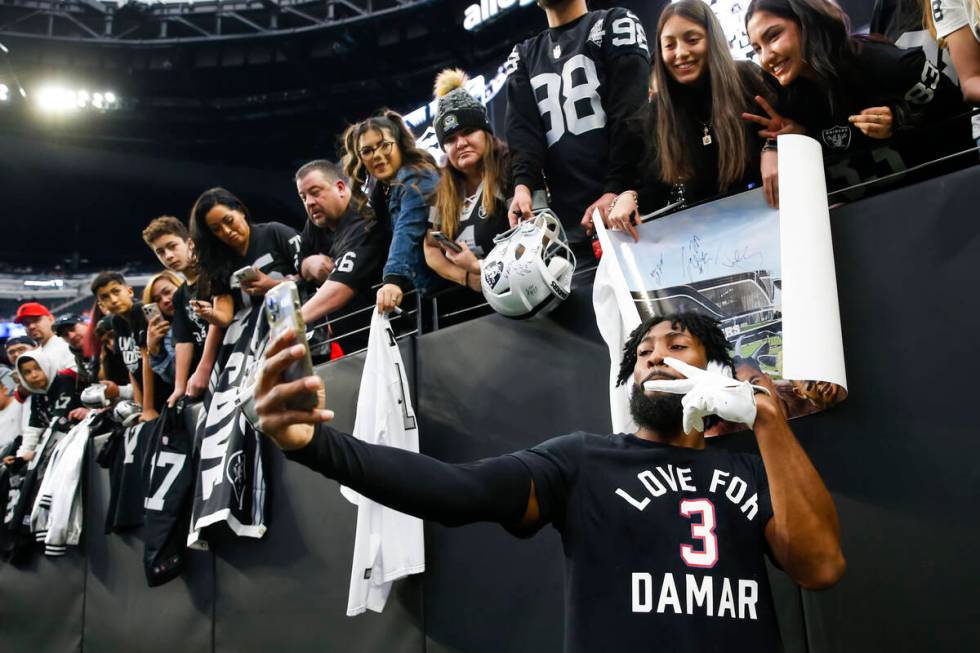 Raiders cornerback Nate Hobbs takes pictures with fans before an NFL game at Allegiant Stadium ...