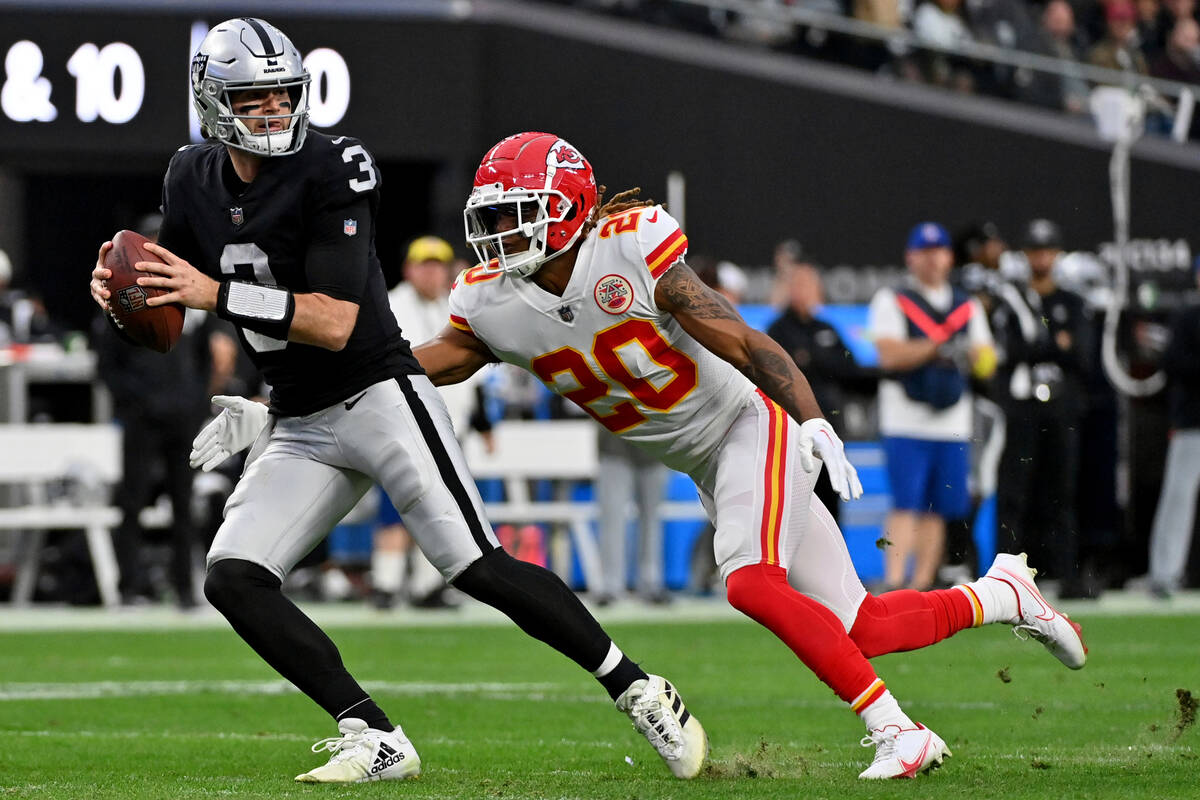 Las Vegas Raiders quarterback Jarrett Stidham, left, is sacked by Kansas City Chiefs safety Jus ...