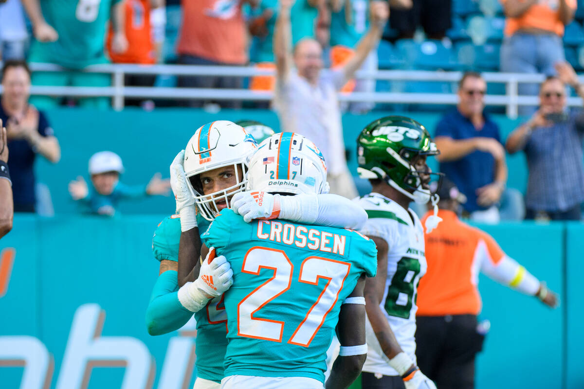 Miami Dolphins linebacker Duke Riley (rear) and Miami Dolphins defensive back Keion Crossen (27 ...