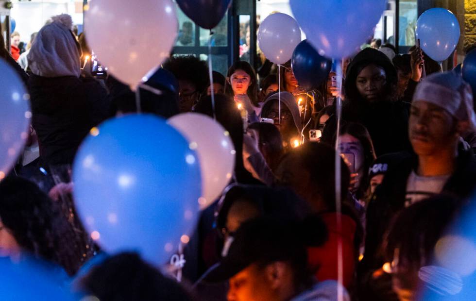 Friends and family of Ashari Hughes, 16, hold candles during a celebration of her life at Cente ...