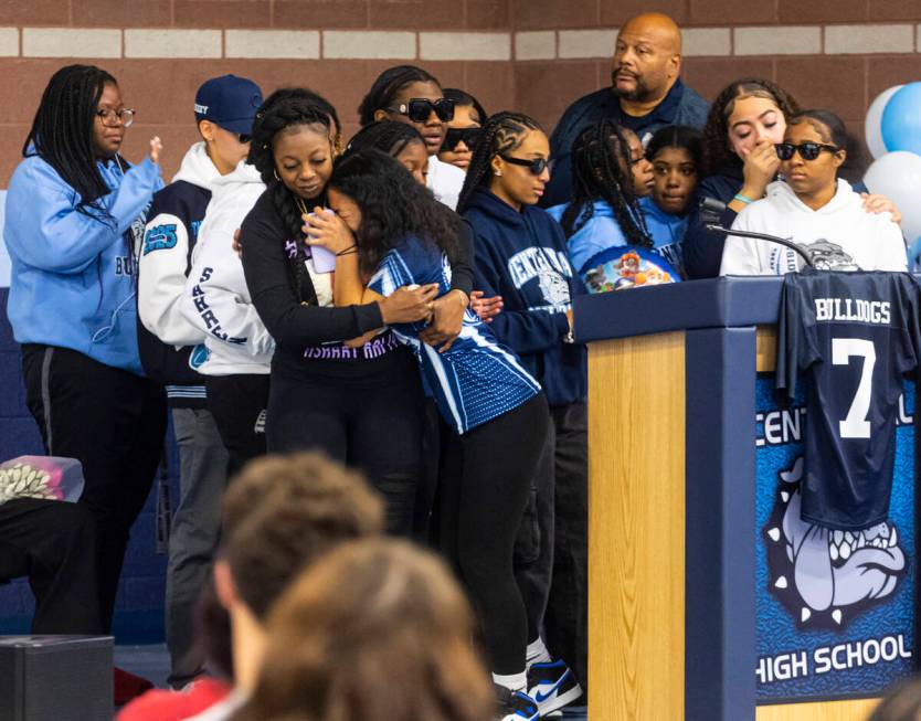 Twayne Hughes, center left, mother of Ashari Hughes, embraces her friend and former teammate Al ...