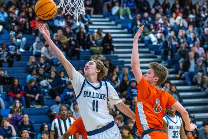 Centennial guard Toby Roberts (11) gets inside of Bishop Gorman guard Eli Bradley (0) for a lay ...