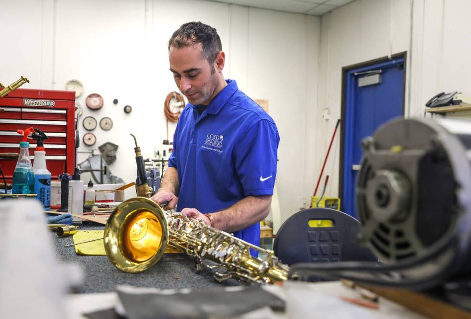 Tim Adelson, a musical instrument repair technician for the Clark County School District, repai ...