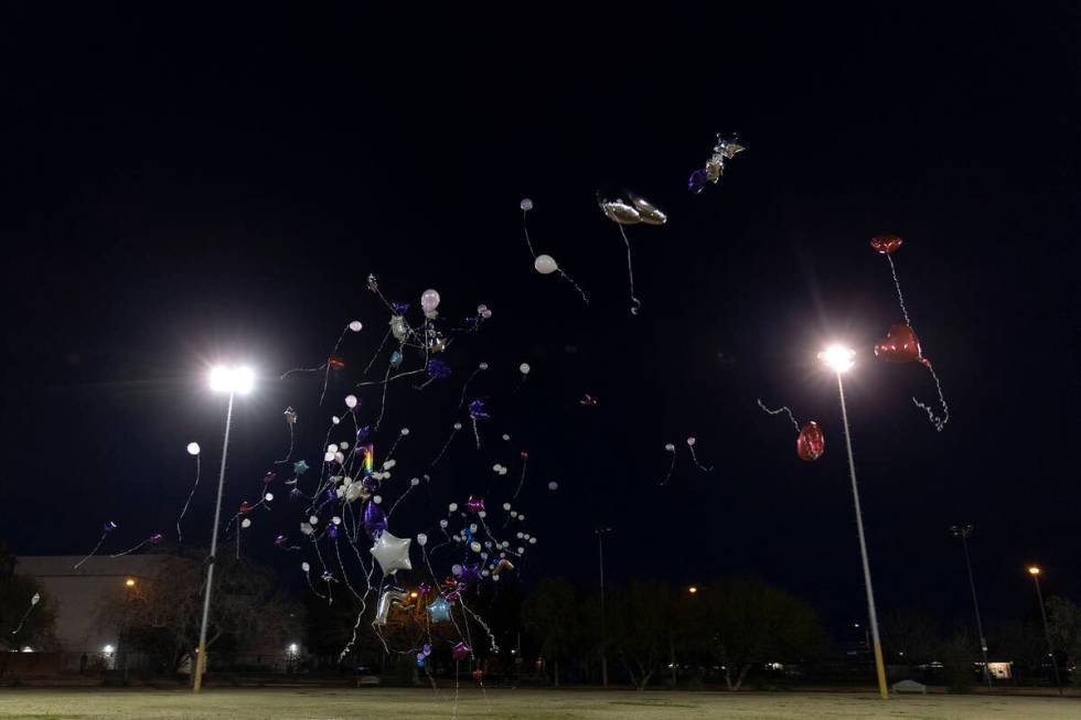 Balloons, released in honor of Ashari Hughes, fly into the night sky outside Doolittle Communit ...