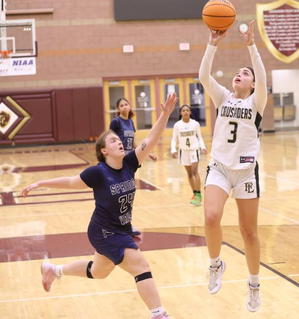 Faith Lutheran's Gabby Libonati (3) shoots under pressure from Spring Valley's Delaney Bartlett ...