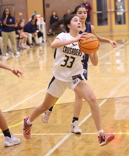 Faith Lutheran's Emma Herpin (33) drives to the basket past Spring Valley during the second hal ...