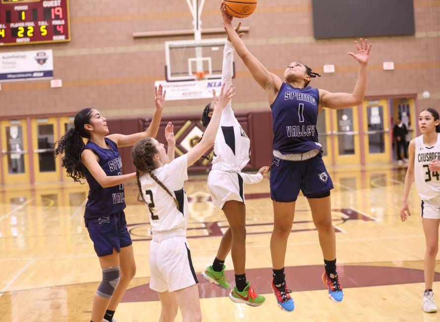 Spring Valley's Mia Ervin (1) grabs a rebound under pressure from Faith Lutheran's Tamiah Harri ...