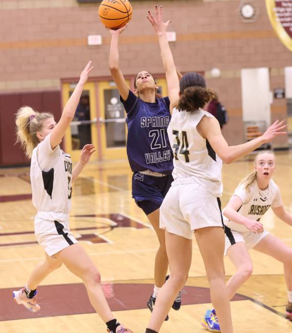 Spring Valley's Charolette De Lisle (21) shoots between Faith Lutheran's Raina Forgue, left, an ...