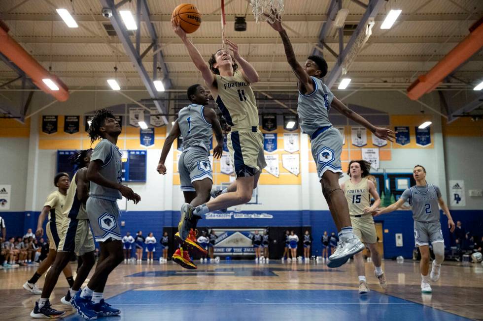 Foothill’s Zakary Abdalla (11) shoots against Desert Pines’ Kameron Ricks (1) and ...