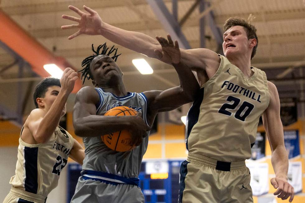 Desert Pines’ Greg Burrell, center, rebounds the ball between Foothill’s Shawn Sa ...