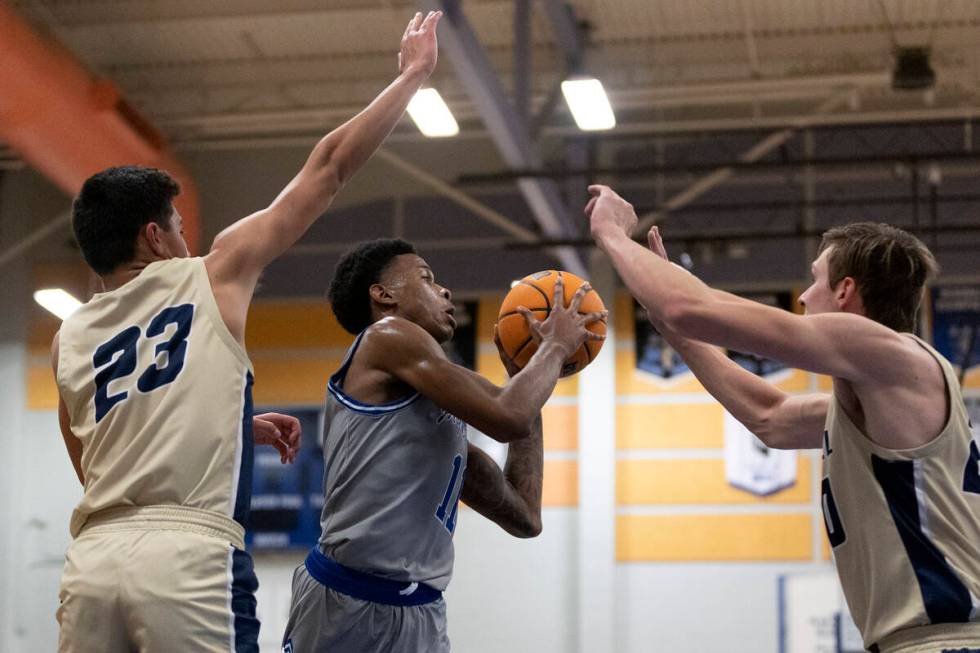 Desert Pines’ Evan Tatum (11) passes between Foothill’s Shawn Salazar (23) and Br ...