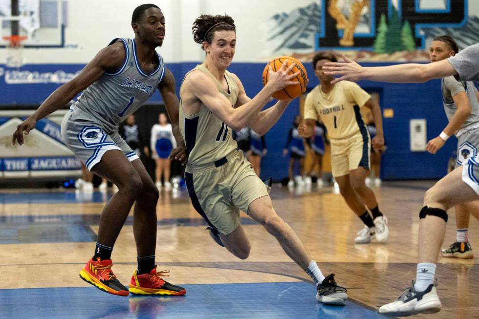 Foothill’s Zakary Abdalla (11) drives around Desert Pines’ Kameron Ricks (1) duri ...