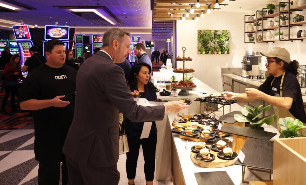 CRAFTkitchen snack bar attendant Sam Wolfskill serves samples to Nevada State Senator Scott Ham ...