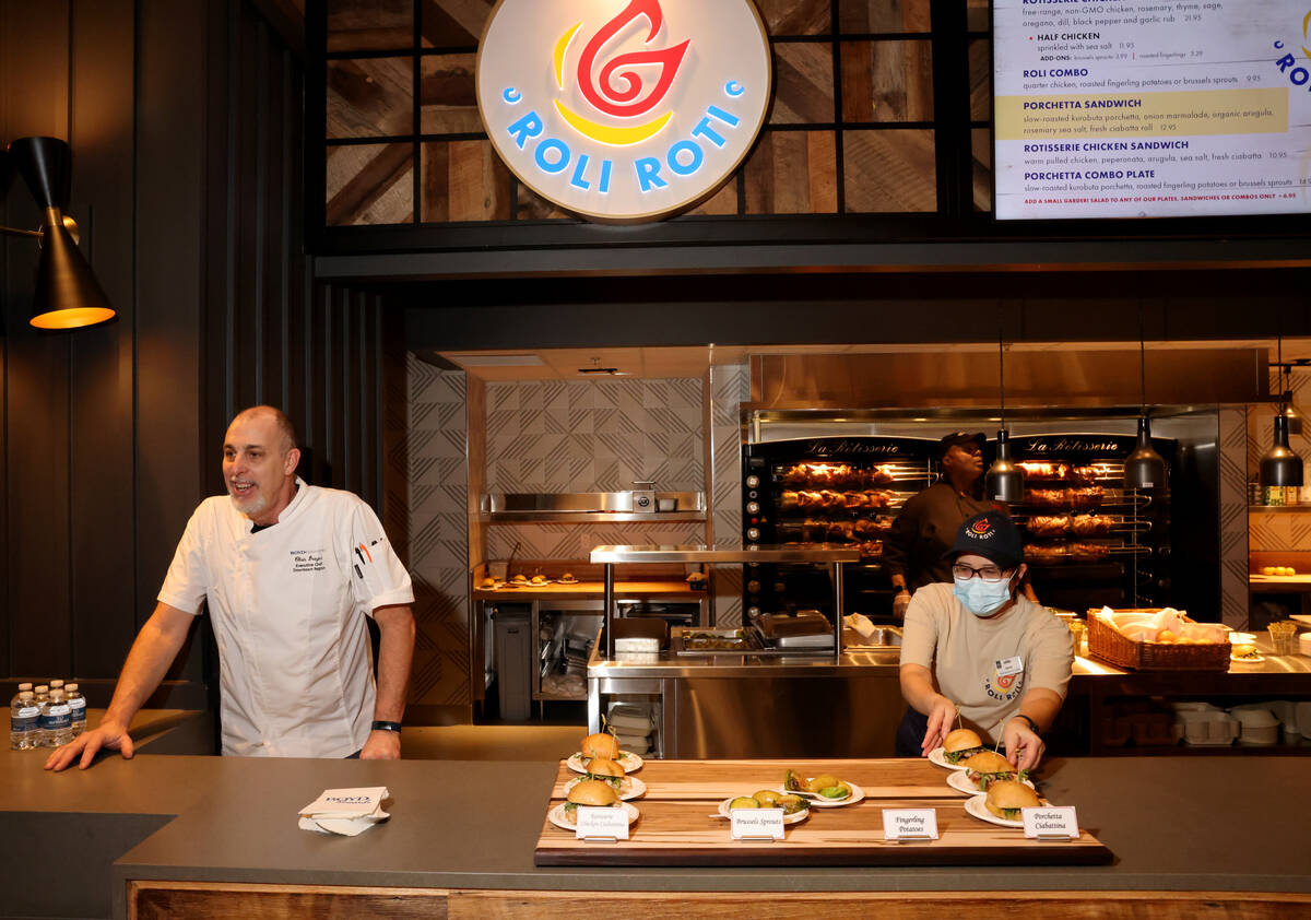 Roli Roti Gourmet Rotisserie snack bar attendant Phon Phiang prepares snack samples as Boyd Gam ...