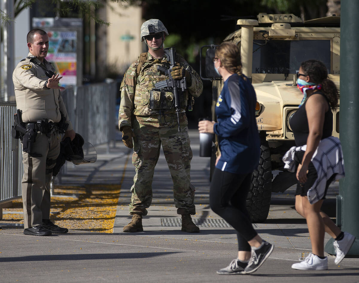 Protesters walk past law enforcement outside Las Vegas City Hall on Wednesday, June 3, 2020, in ...