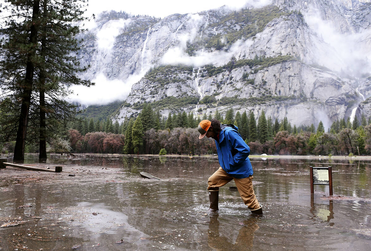 FILE - Kevin Kimo Laughlin, a maintenance worker for Aramark, wades back to dry ground as the M ...