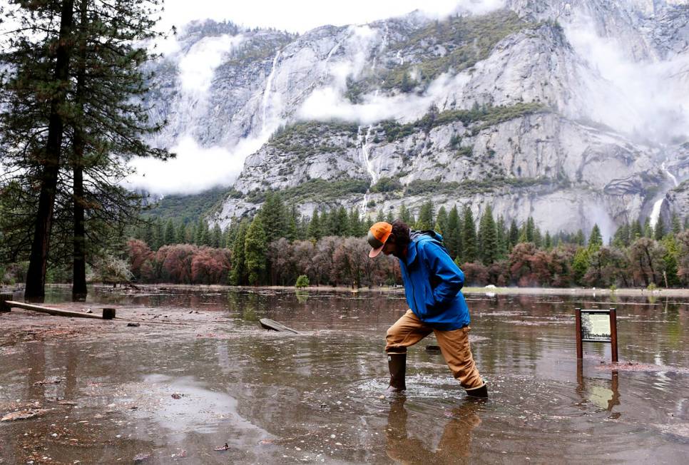 FILE - Kevin Kimo Laughlin, a maintenance worker for Aramark, wades back to dry ground as the M ...