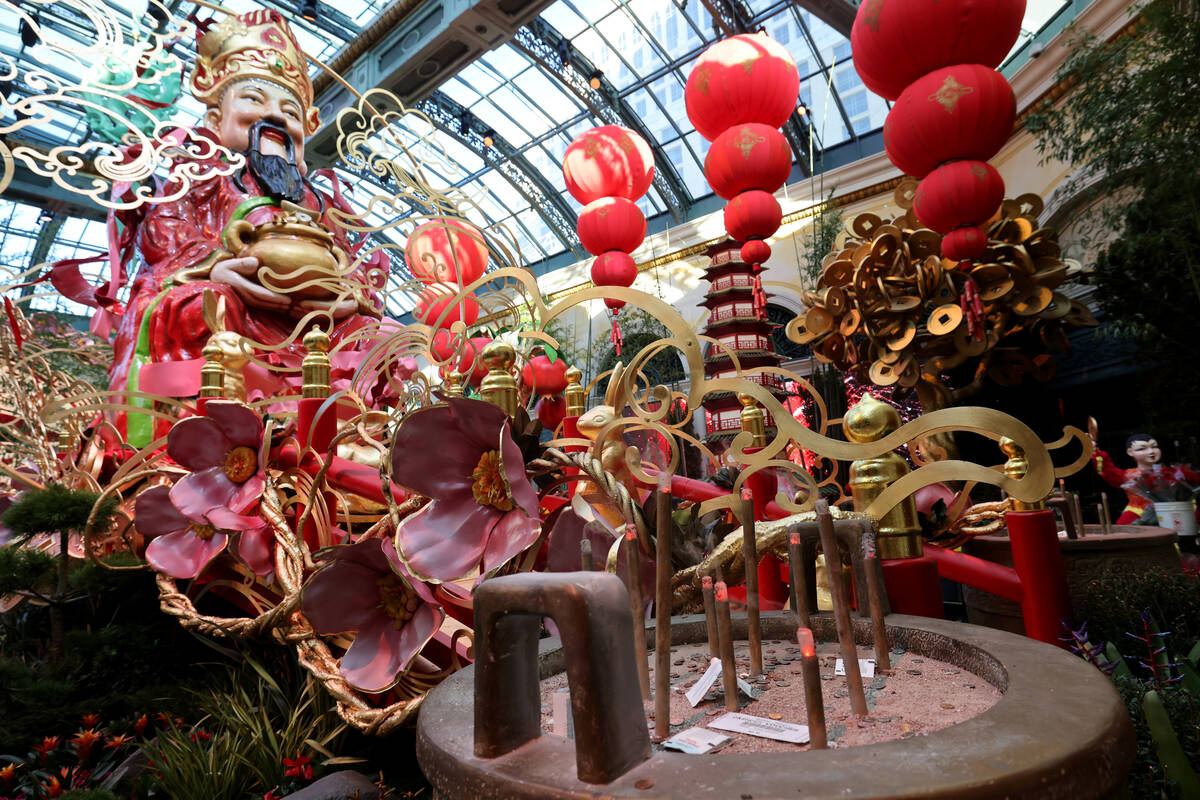 Simulated incense in a ding pot in front of Caishen, the benevolent Chinese god of wealth, in t ...