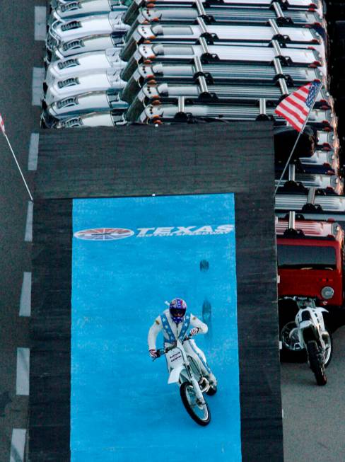 Stunt motorcycle driver Robbie Knievel lands after jumping over 21 Hummers prior to an IndyCar ...