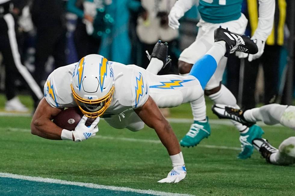 Los Angeles Chargers running back Austin Ekeler (30) leaps into the end zone after a run agains ...