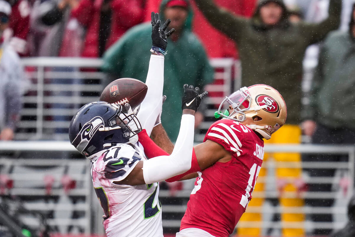 Seattle Seahawks cornerback Tariq Woolen, left, breaks up a pass intended for San Francisco 49e ...