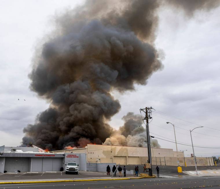 Black smoke and flames rise into the sky as Las Vegas and Clark County Firefighters work a full ...