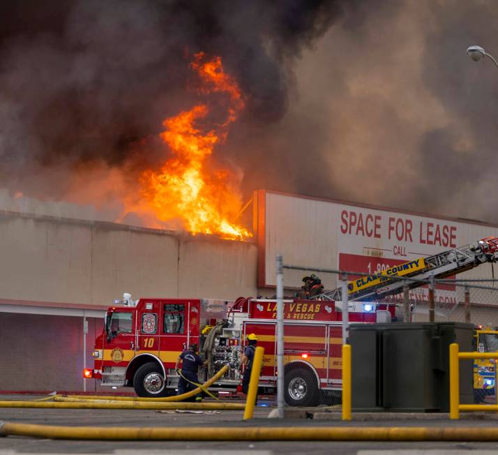 Black smoke and flames rise into the sky as Las Vegas and Clark County Firefighters work a full ...