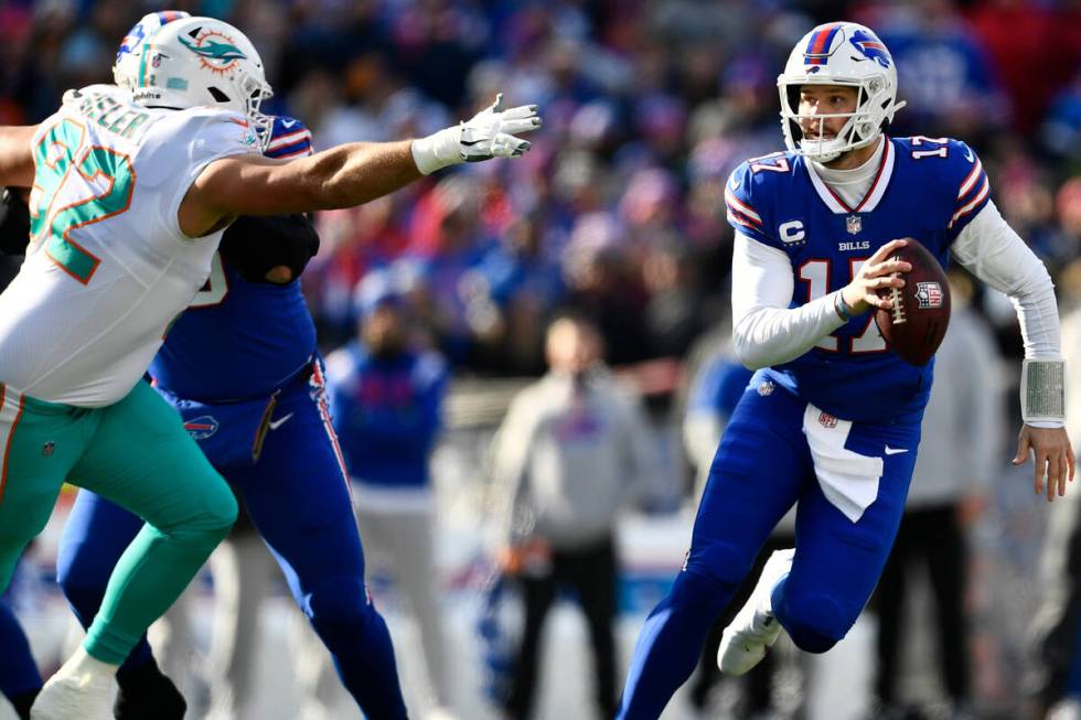 Buffalo Bills quarterback Josh Allen (17) dashes away from Miami Dolphins defensive tackle Zach ...