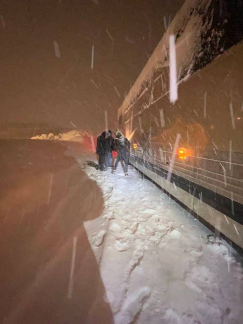 Members of Carrot Top's team are shown are shown chaining up its bus on U.S. Highway 50, on the ...