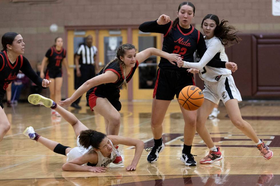 Faith Lutheran’s Leah Mitchell, left, and Emma Herpin, right, dive for the ball against ...