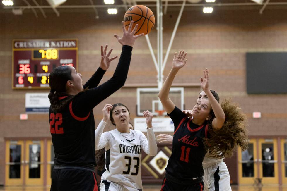 Coronado’s Ashtyn Wick (22) reaches for a rebound after Faith Lutheran’s Emma Her ...