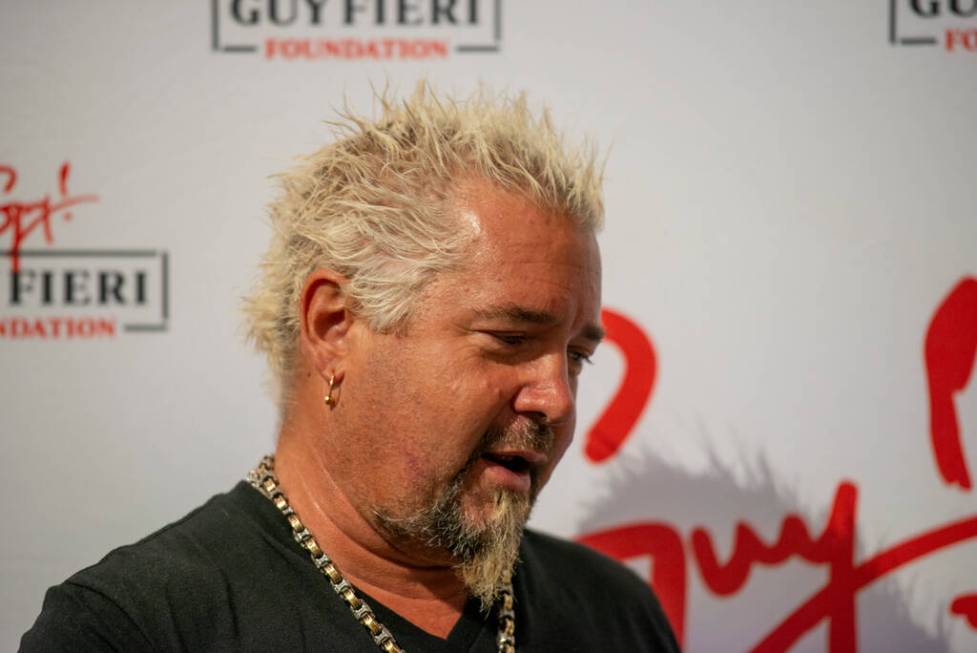 Chef and TV personality Guy Fieri talks to the media during an event honoring veterans and firs ...