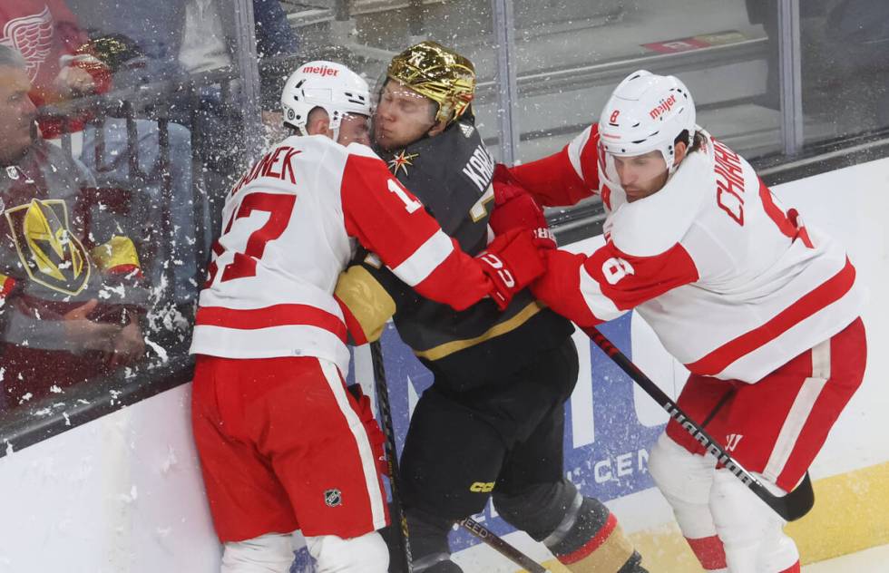 Detroit Red Wings defensemen Filip Hronek (17) and Ben Chiarot (8) take Golden Knights center W ...