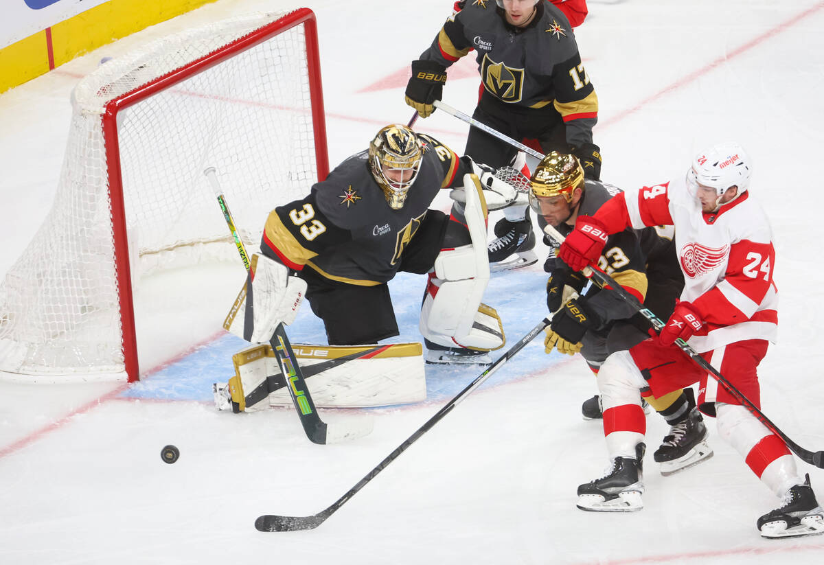 Golden Knights goaltender Adin Hill (33) defends the net as defenseman Alec Martinez (23) and D ...