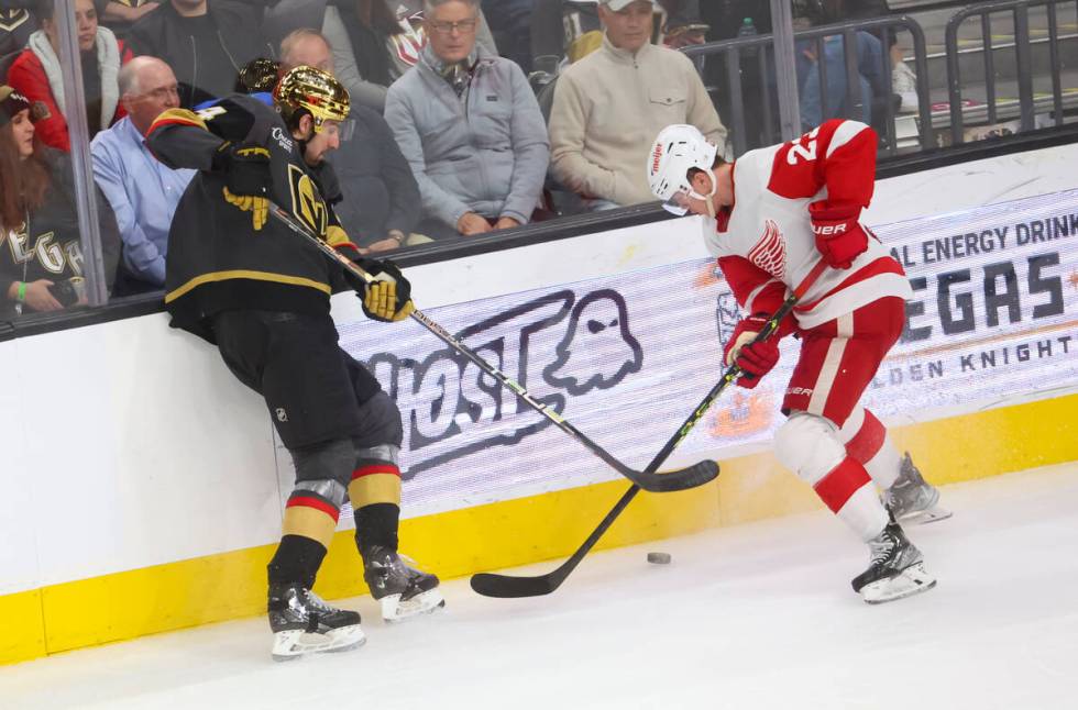 Golden Knights defenseman Nicolas Hague (14) and Detroit Red Wings left wing Lucas Raymond (23) ...