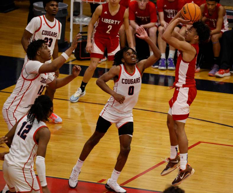 Liberty’s Dedan Thomas Jr., right, attempts a jump shot as Coronado players try to defend dur ...