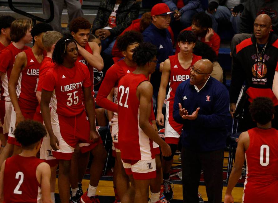 Liberty head coach Kevin Soares speaks to his players during the second half of a basketball ga ...