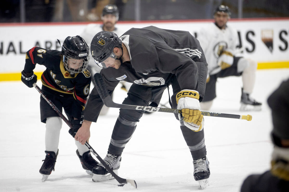 Golden Knights defenseman Brayden McNabb assists Annabelle Hanson of Janesville, Calif., an 8-y ...