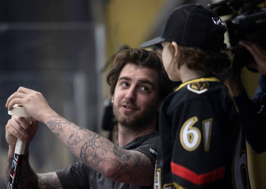 Golden Knights goaltender Logan Thompson tapes a new stick for Annabelle Hanson, 8, during prac ...