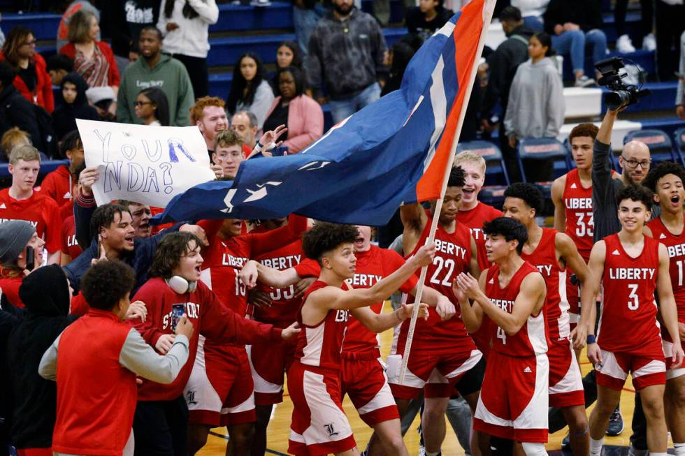 Liberty players celebrate their 72-67 victory against Coronado after overtime of a basketball g ...