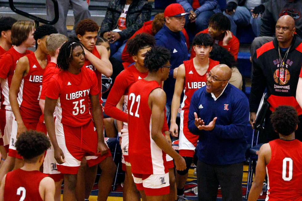 Liberty head coach Kevin Soares speaks to his players during the second half of a basketball ga ...