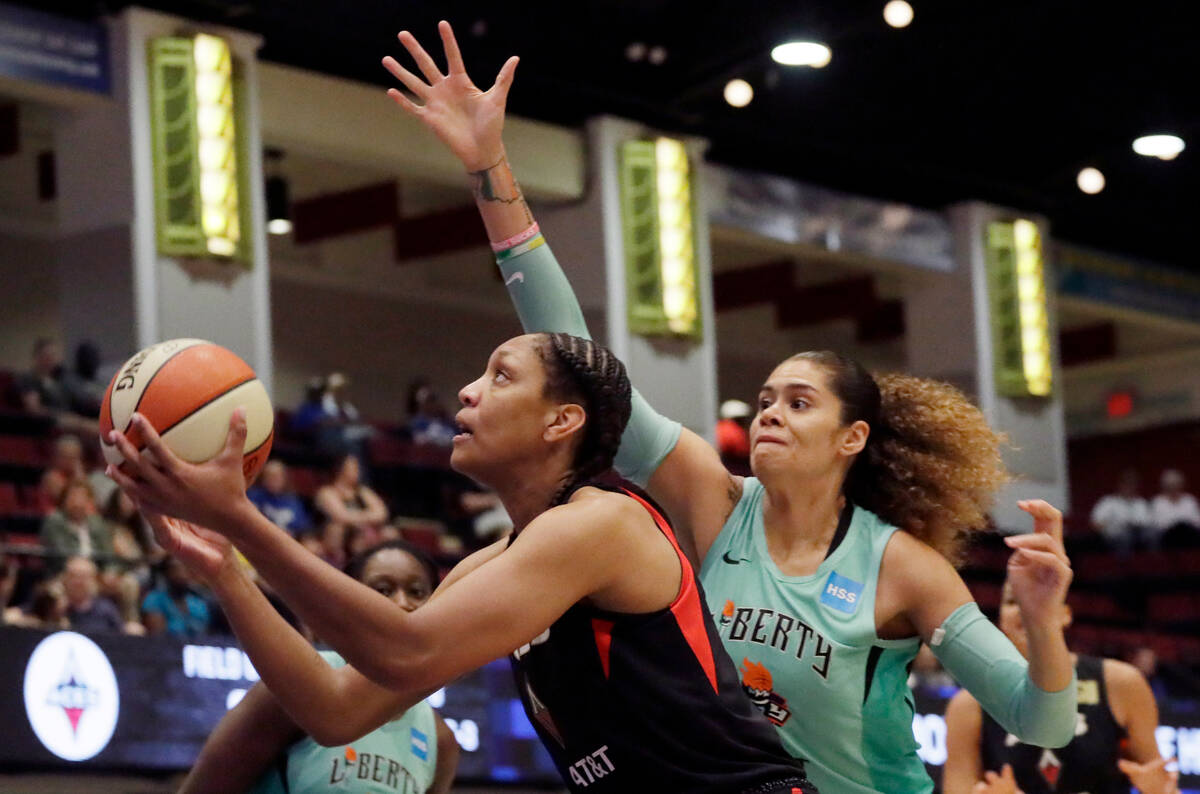 Las Vegas Aces' A'ja Wilson, left, drives past New York Liberty's Amanda Zahui B, of Sweden, du ...