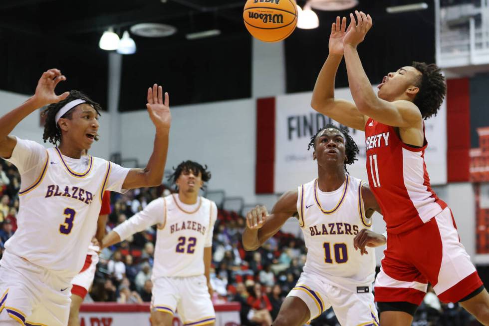 Liberty's Dedan Thomas (11) loses the ball while leaping for a pass as Durango's Jevon Yapi (3) ...