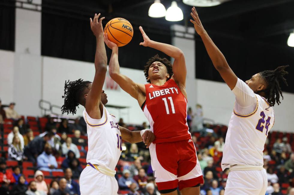 Liberty's Dedan Thomas (11) takes a shot under pressure from Durango's Tylen Riley (10) and Taj ...