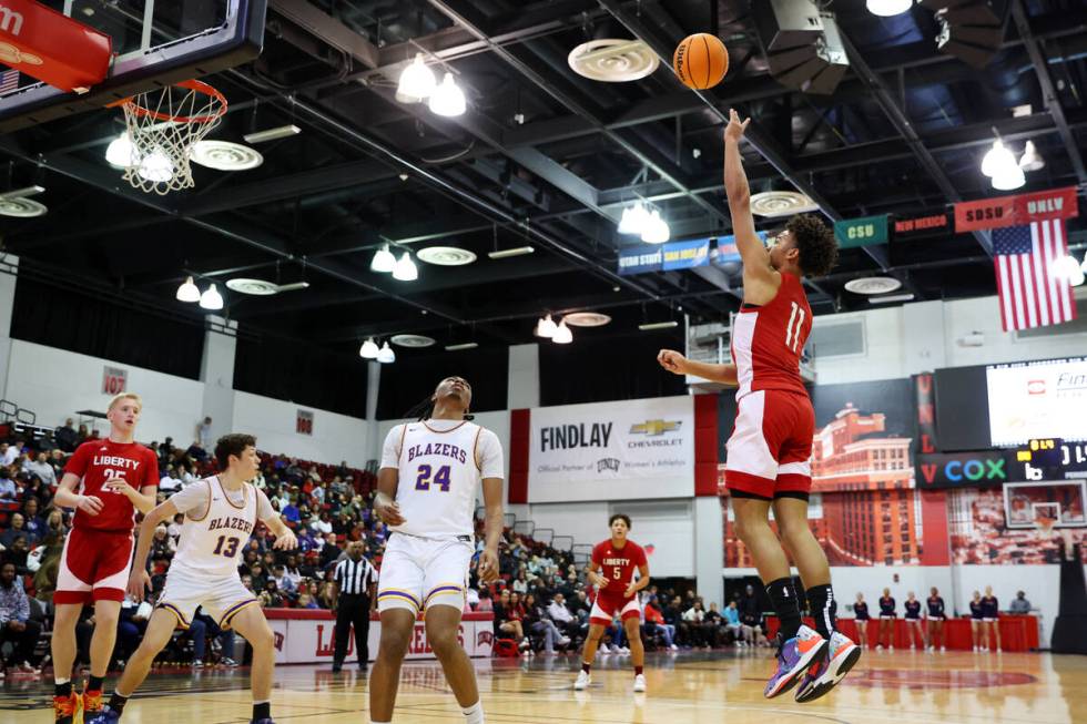 Liberty's Dedan Thomas (11) takes a shot as Durango's Taj Degourville (24) looks on in the firs ...