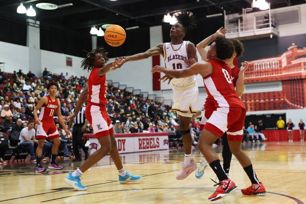 Durango's Tylen Riley (10) shoots the ball under pressure from Liberty's Amare Oba (35), Angelo ...